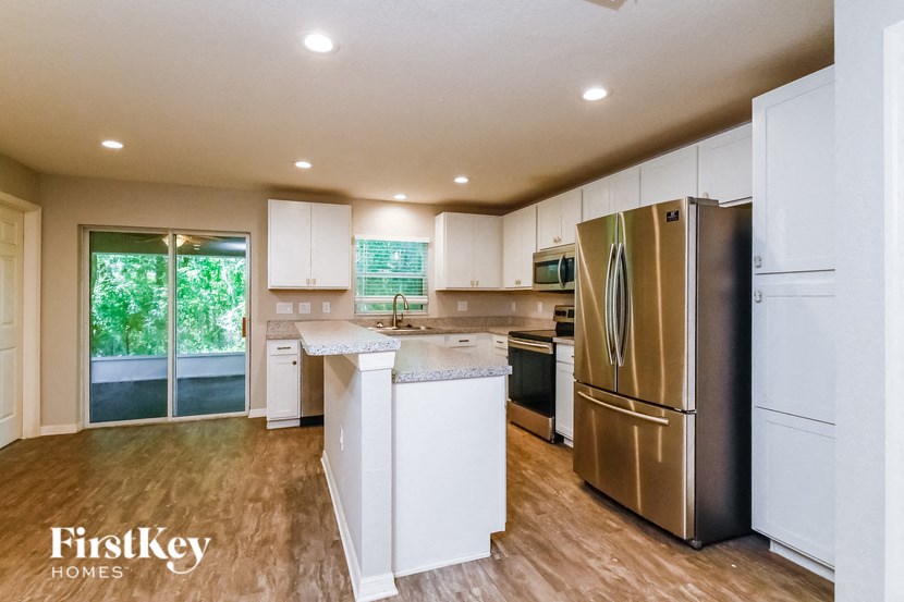 a kitchen with white cabinets and a stainless steel refrigerator