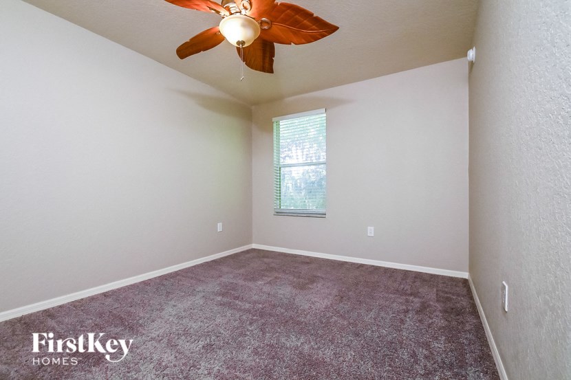 a bedroom with carpet and a ceiling fan