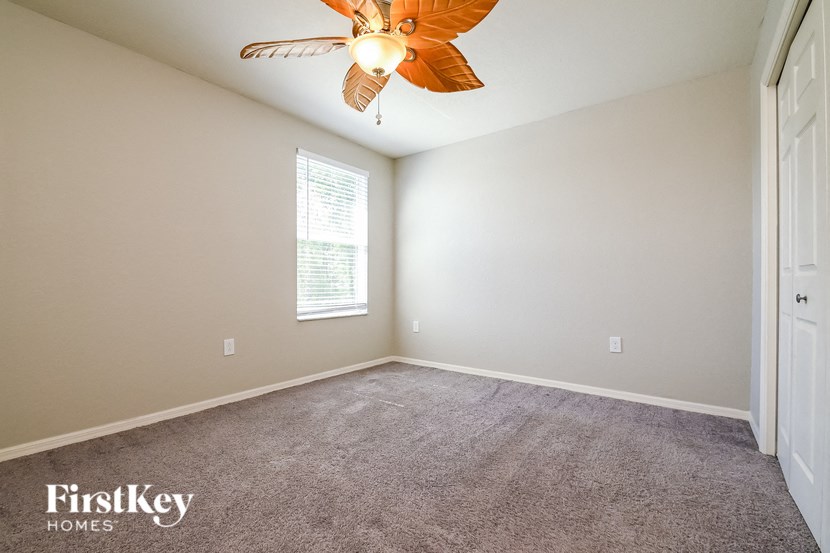 a bedroom with carpet and a ceiling fan