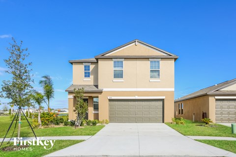 a house with a garage door and a sidewalk in front of it