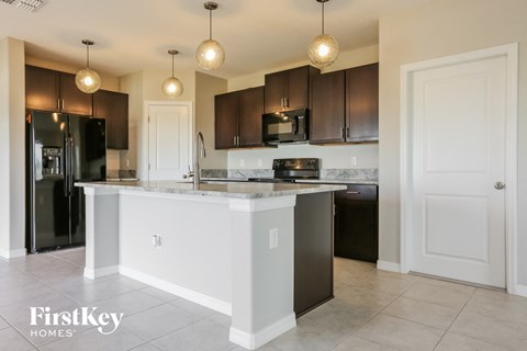 a kitchen with a large island and black appliances