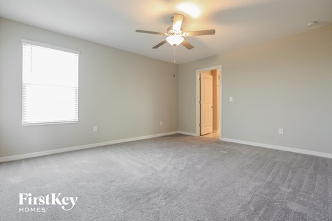 the master bedroom is spacious and has a ceiling fan