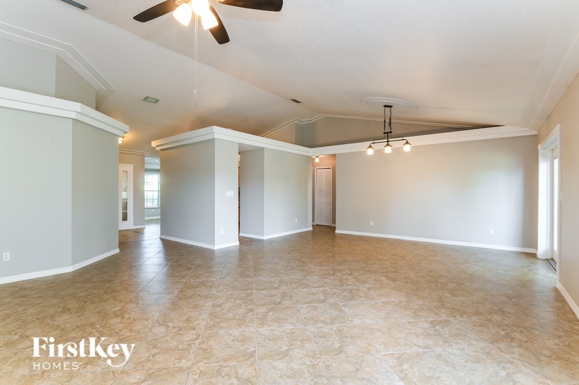 A spacious room with a ceiling fan and lighting fixtures.