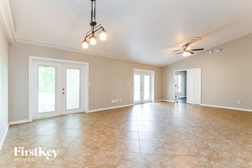 A spacious room with a tiled floor and a ceiling fan.