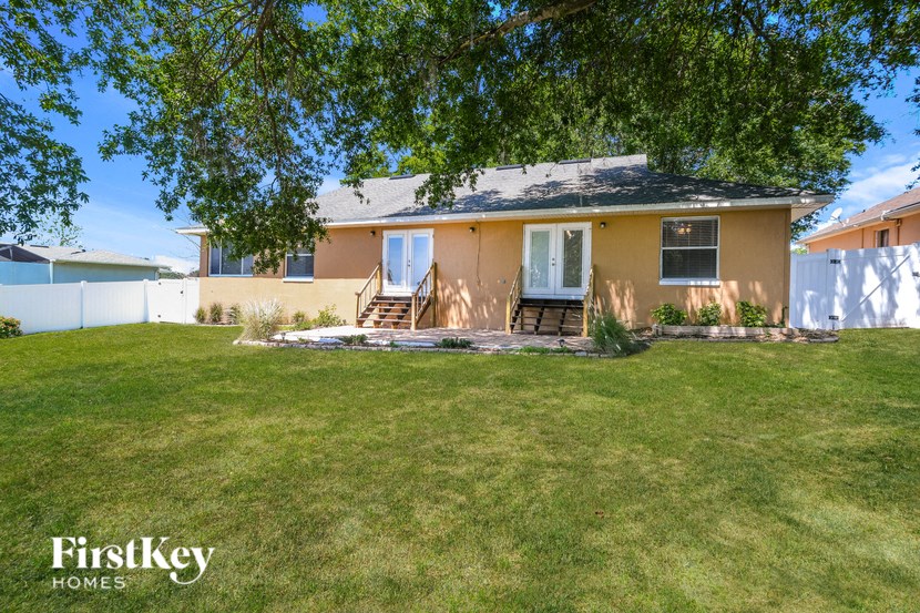 A house with a lawn and trees in the front yard.