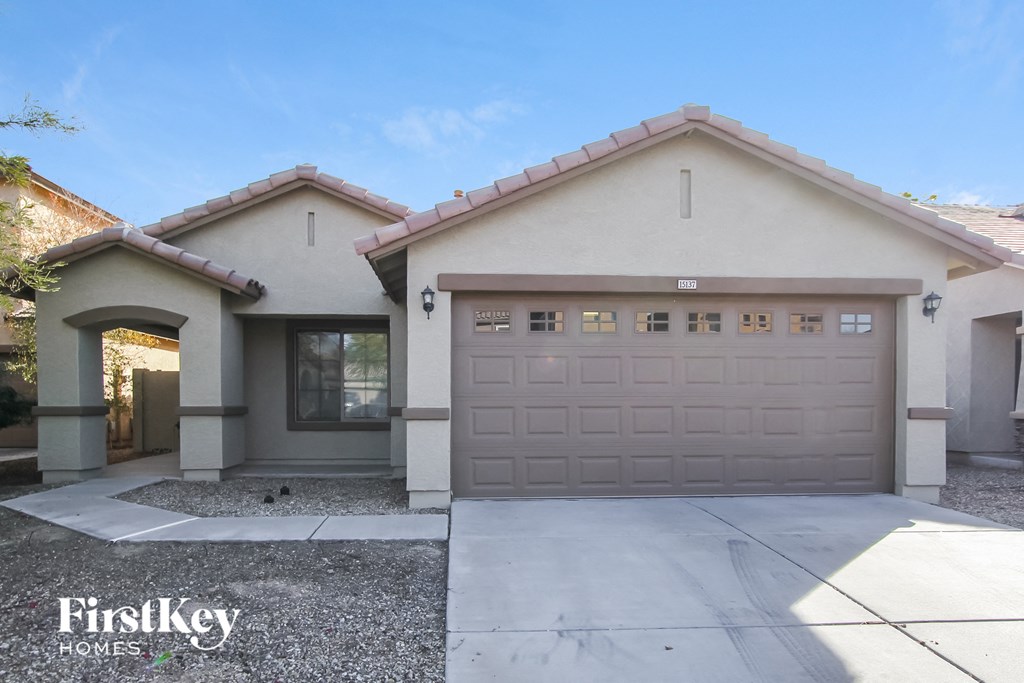 A house with a garage and a driveway in front of it.