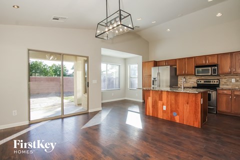 A kitchen with wooden cabinets and a wooden island with a microwave on top.