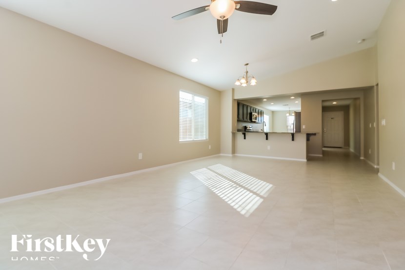 A spacious, empty room with a fan and a large window.