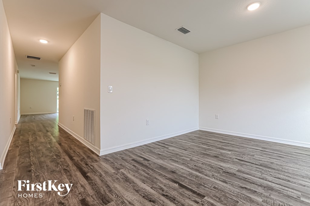 a living room with wood flooring and white walls