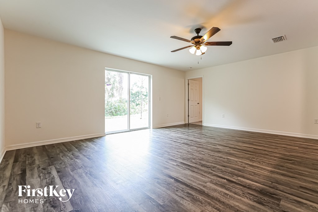the living room of an empty house with a ceiling fan