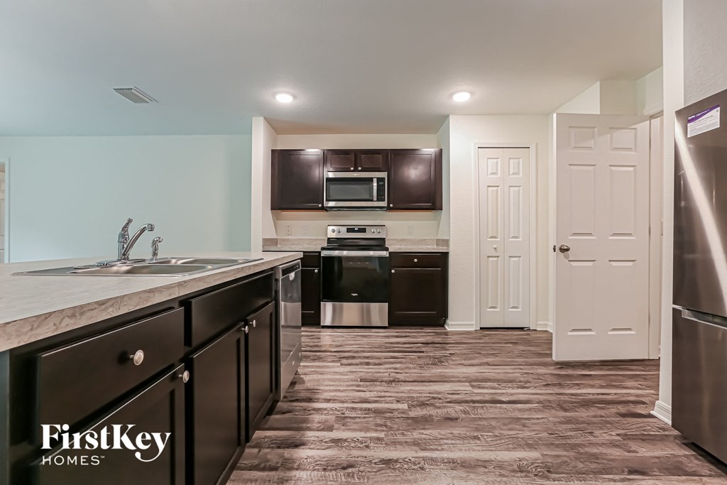 a kitchen with stainless steel appliances and a wooden floor