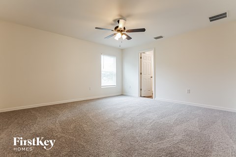 a living room with carpet and a ceiling fan