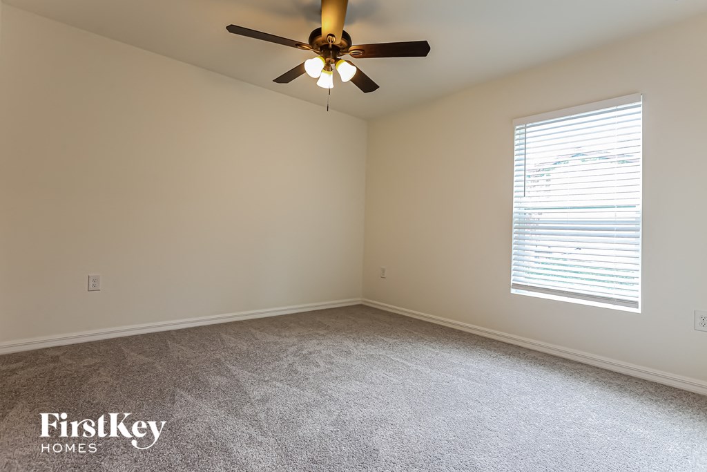 a bedroom with a ceiling fan and a window