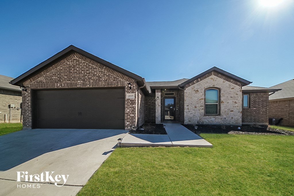 a large brick house with a driveway and a garage door