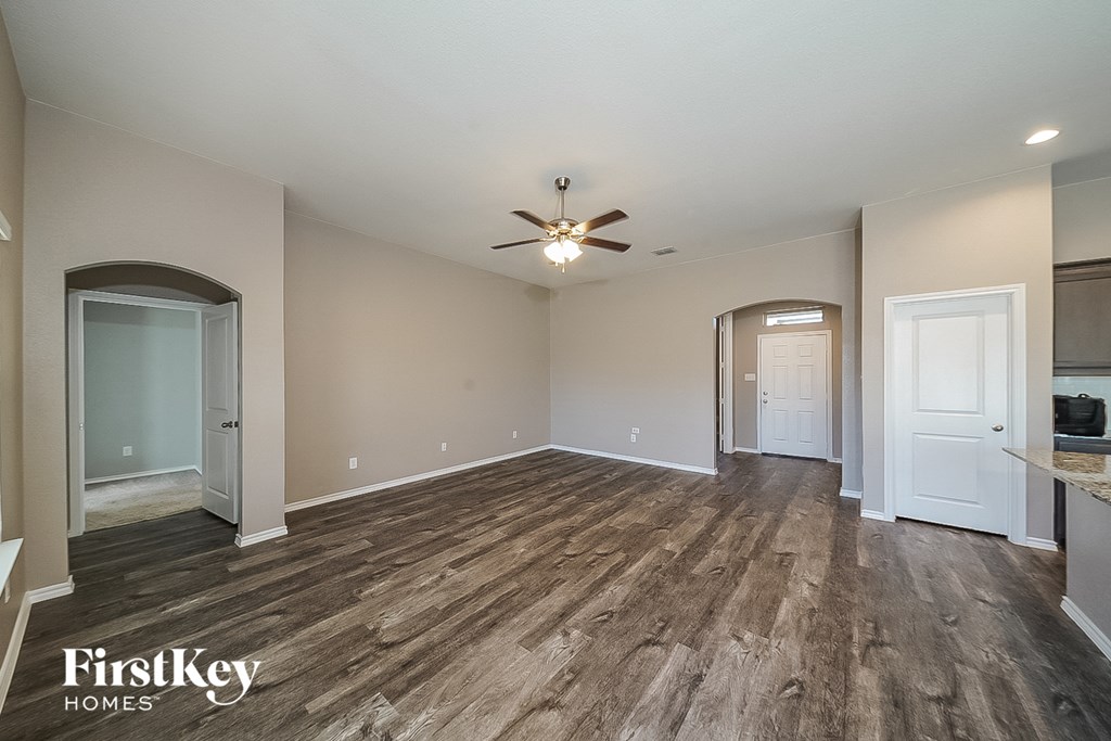 a living room with wood flooring and a ceiling fan