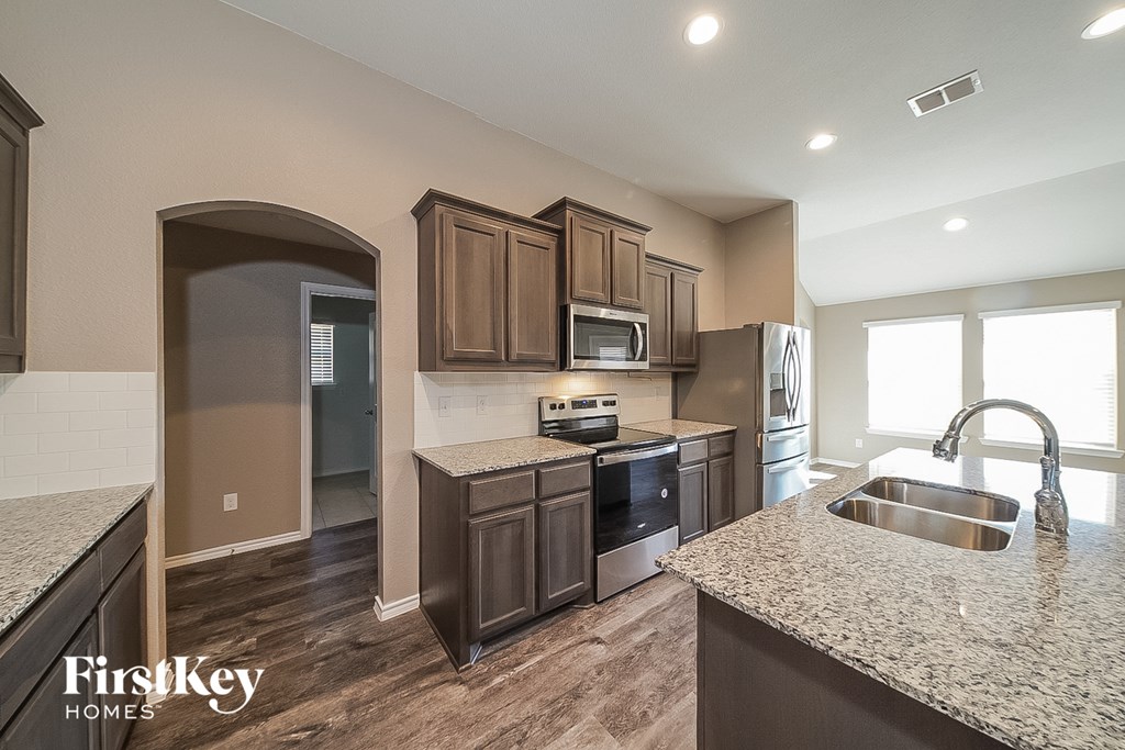 a kitchen with wooden cabinets and granite counter tops and a sink