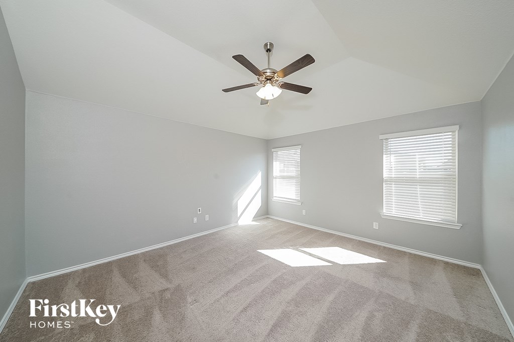 the living room of an empty home with a ceiling fan