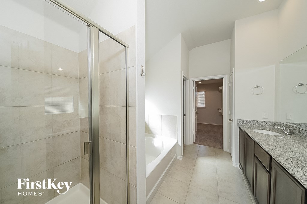 a bathroom with a shower and a sink and a mirror