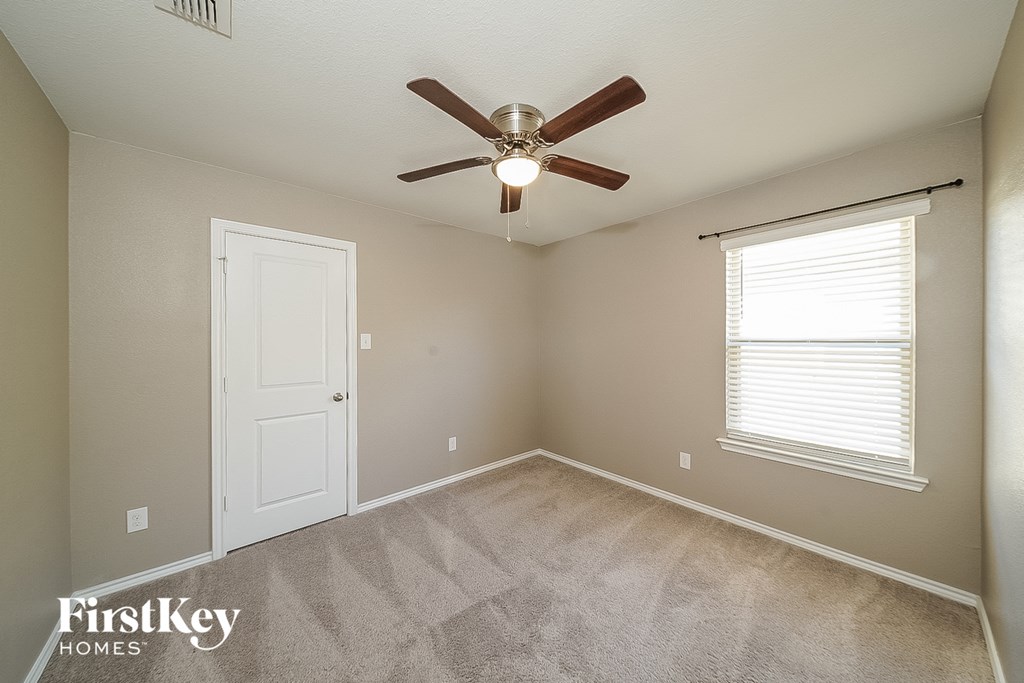 the master bedroom has a ceiling fan and carpeted flooring