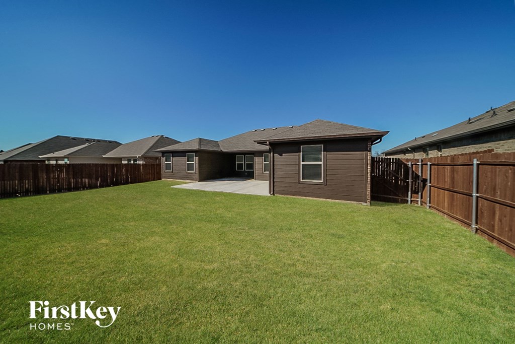 a backyard with a yard and a house with a fence