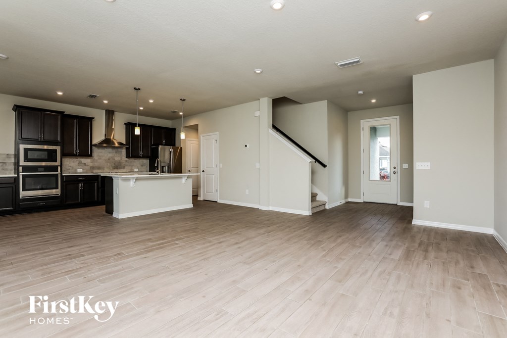 an open kitchen and living room with wood flooring