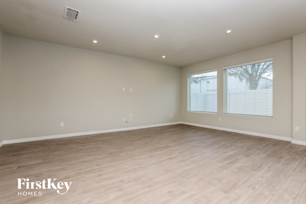 the spacious living room with wood flooring and large windows