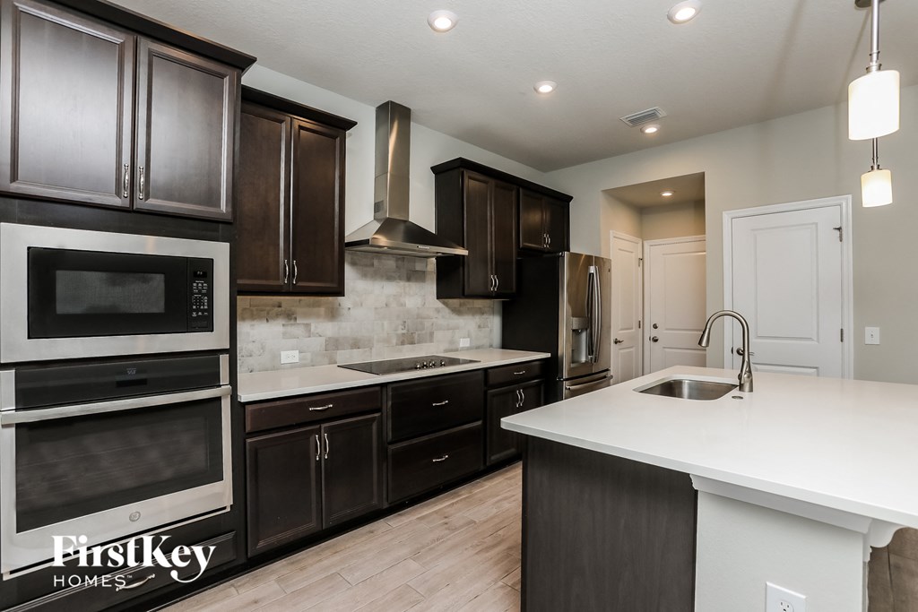 a kitchen with dark wood cabinets and a white counter top