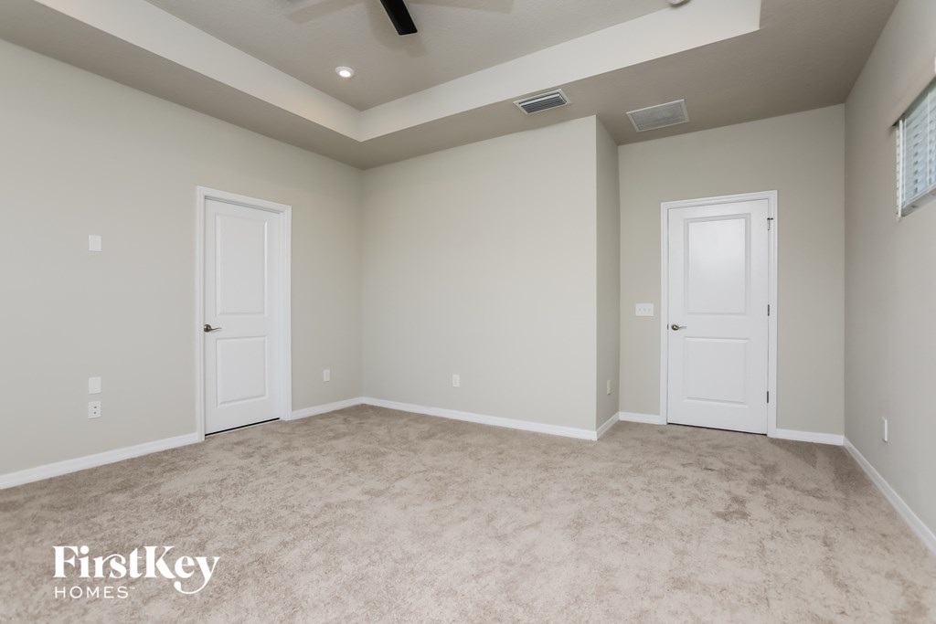 a empty room with two doors and a carpeted floor