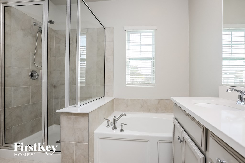 a bathroom with a tub and a shower and a sink