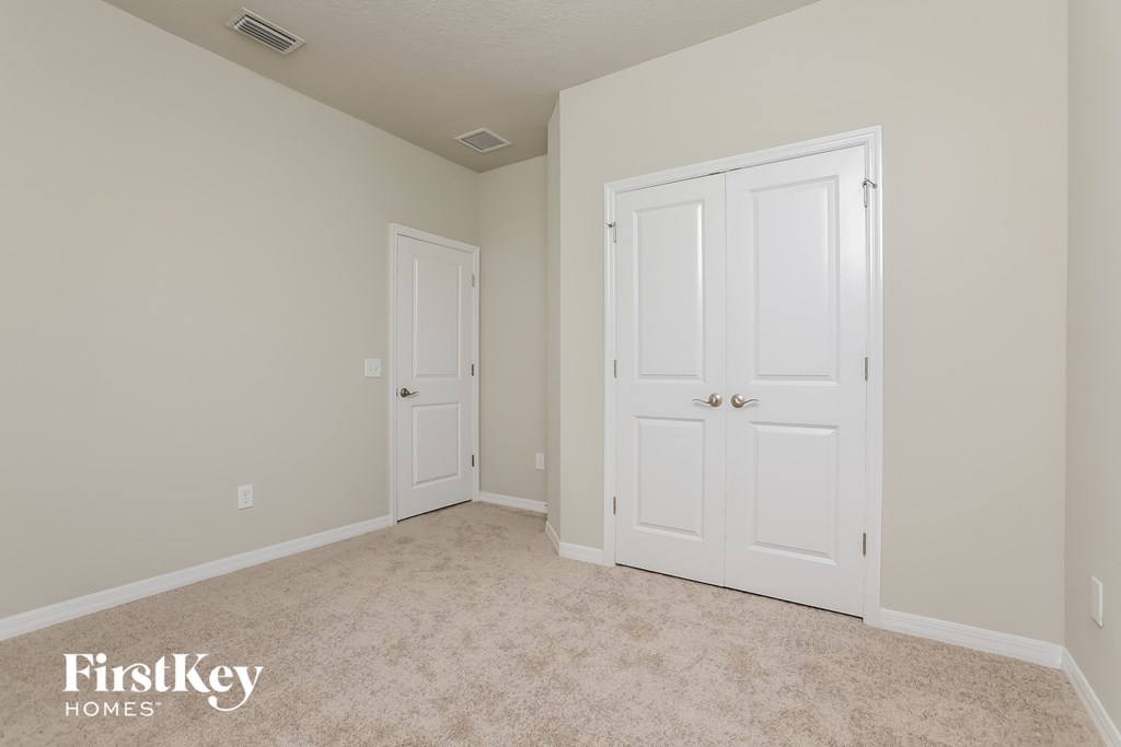 a bedroom with two closets and a carpeted floor