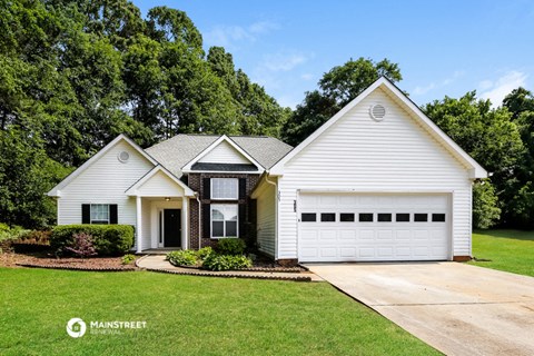 a white house with a white garage door and a lawn