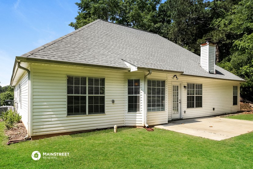 the front of a white house with white shutters and a porch