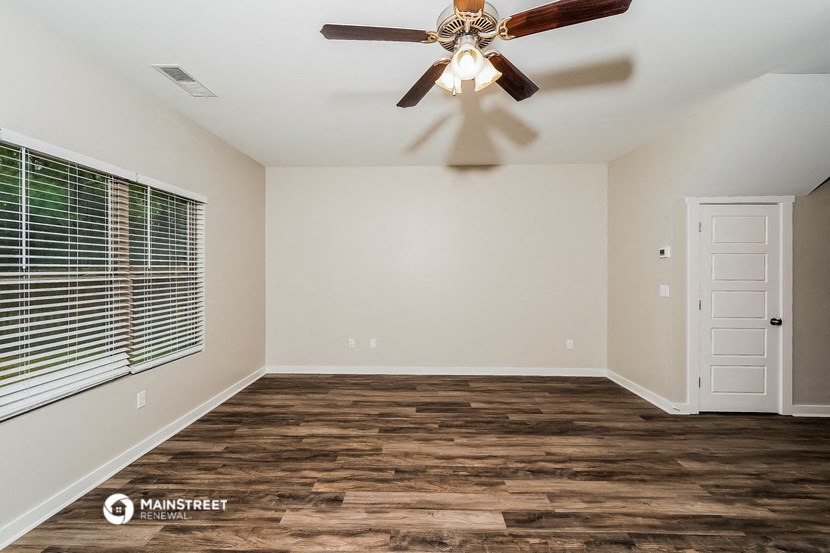 an empty room with a ceiling fan and a window