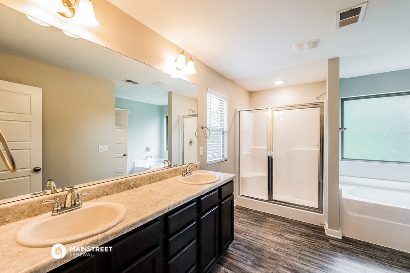 a bathroom with two sinks and a shower