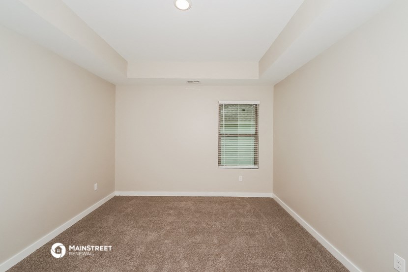 a empty room with carpet and a window