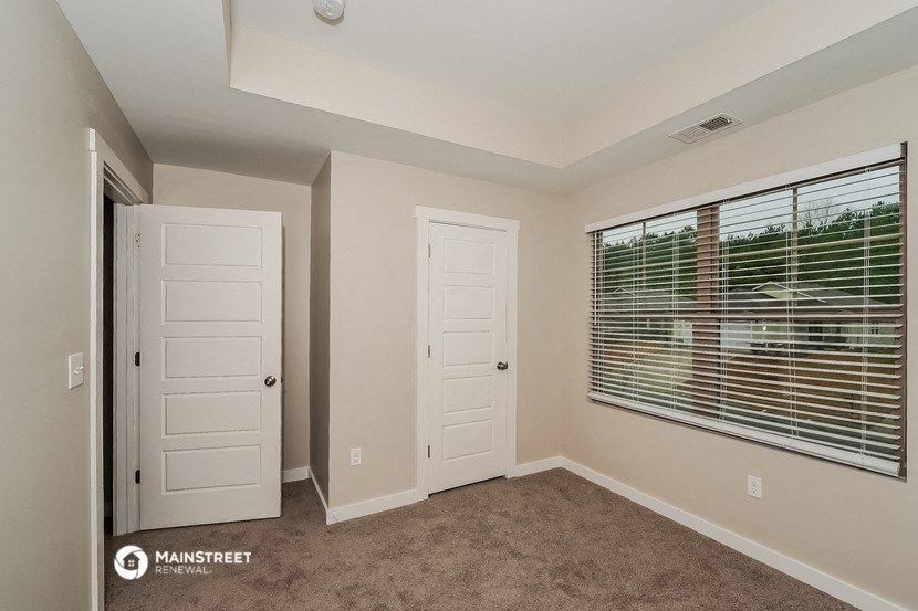 a room with a window and two doors and a closet