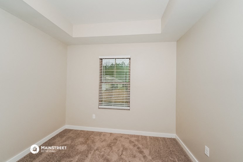 an empty room with a window and a carpet