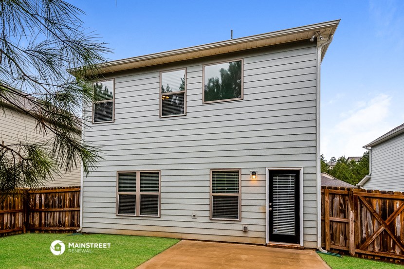 a white house with a wooden fence and grass