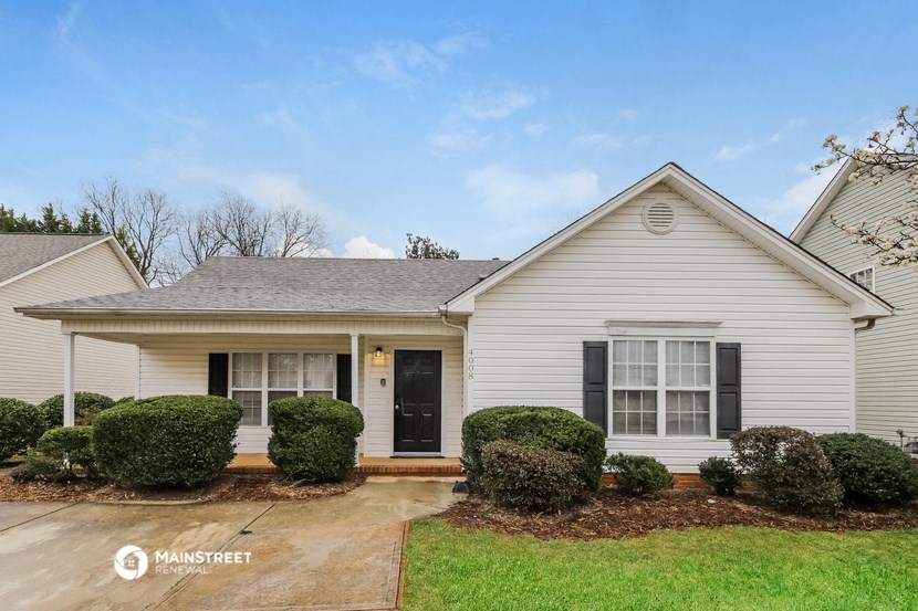a white house with bushes in front of it