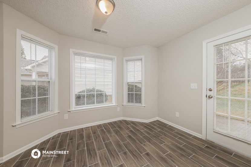 the living room of an empty house with wood flooring