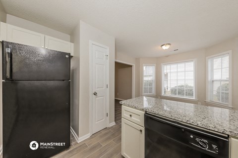 the kitchen of our studio apartment atrium with granite counter top and black refrigerator