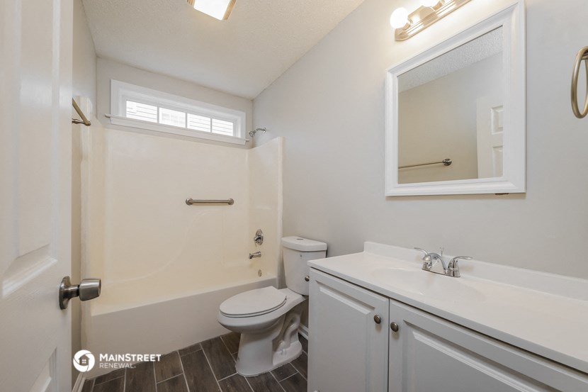a bathroom with a toilet and a sink and a mirror
