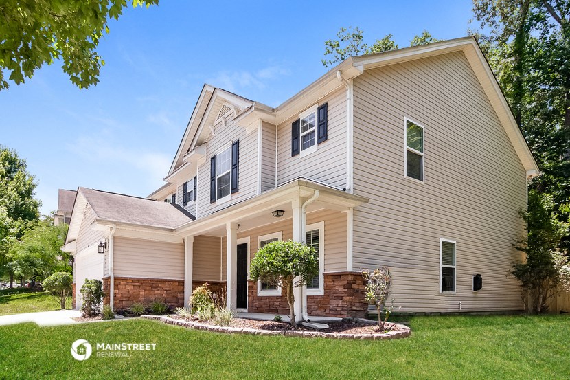 a white house with a brick porch and a lawn