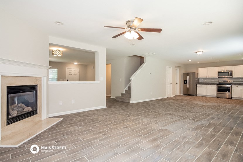 the living room with fireplace and tile flooring