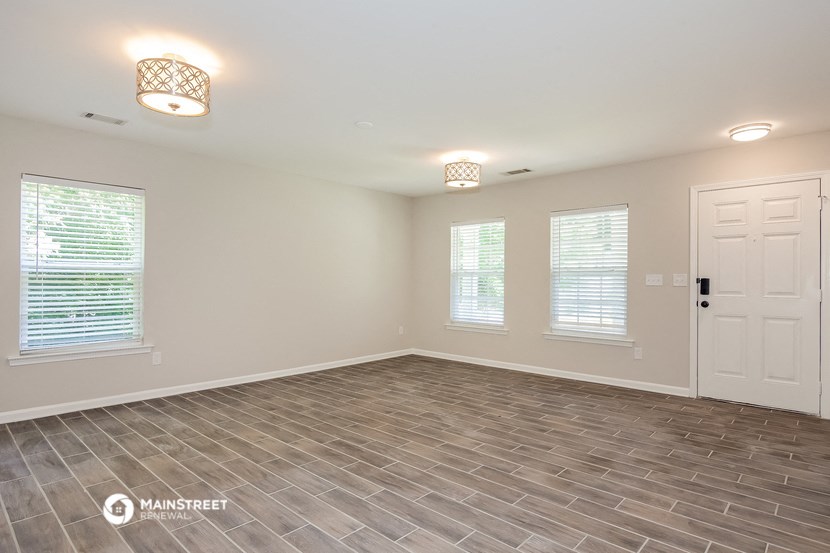 the living room of a new home with a tile floor and a white door