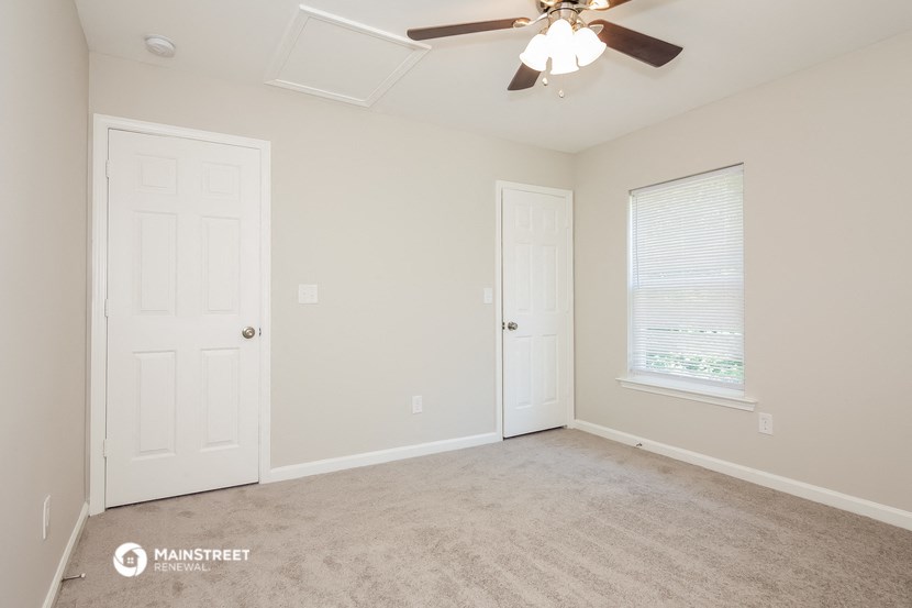 a bedroom with a ceiling fan and a closet