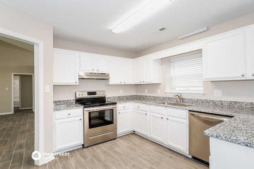 a kitchen with white cabinets and stainless steel appliances