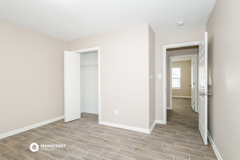 the living room and hallway of an apartment with tile flooring