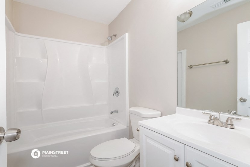 a white bathroom with a sink toilet and shower