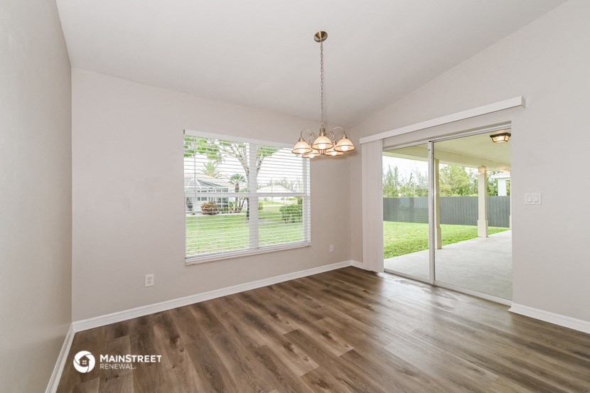 the living room and dining room of a house with wood floors and a large window